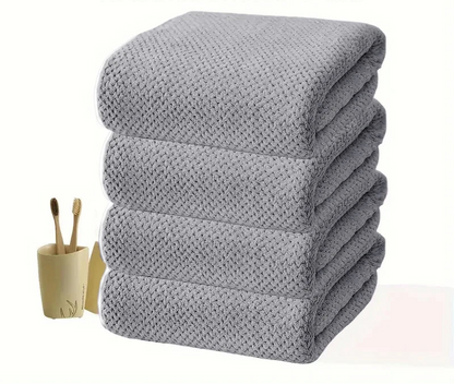 Vier übereinanderliegende Badetücher in Stone Grey mit ruhiger Textilstruktur