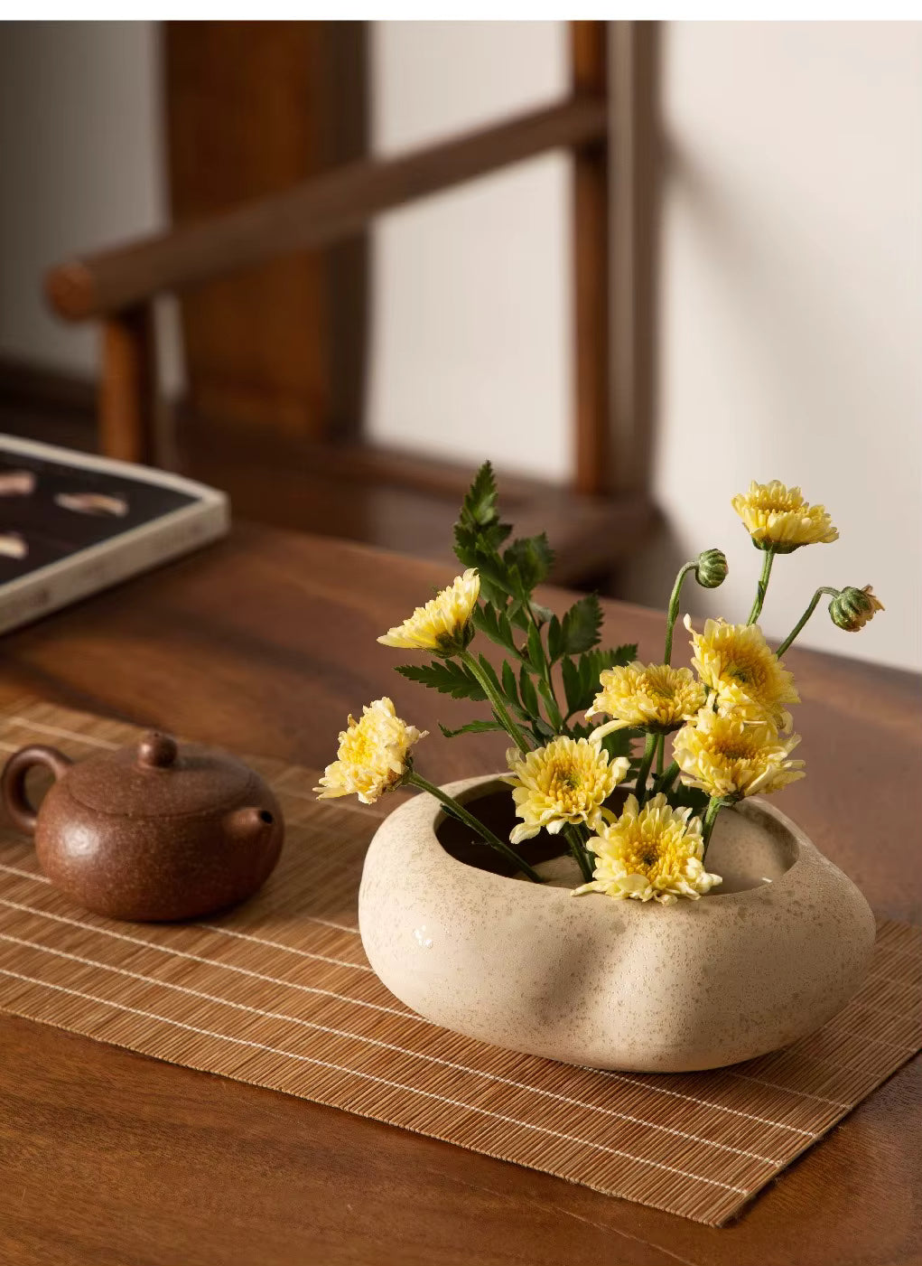 Keramikvase mit Blumenstielen, sanfte Farben, harmonische Tischdekoration