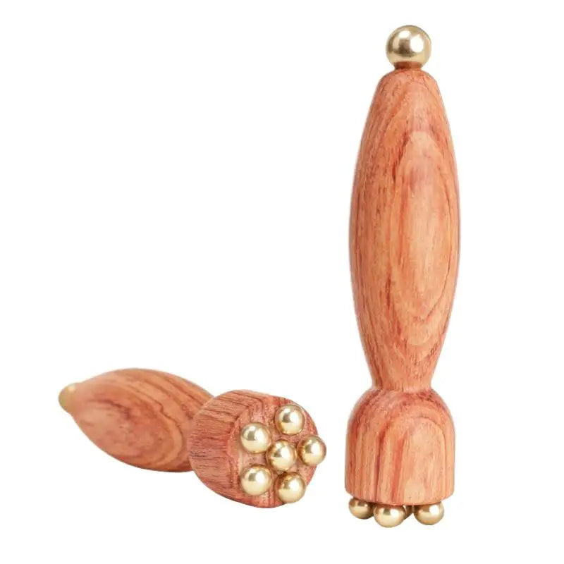Minimalistischer Augen-Massagestab aus Messing und Holz auf hellem Hintergrund