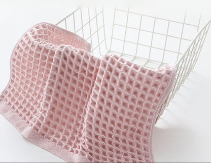Baumwoll-Handtücher mit Waffelstruktur in einem Wäschekorb im Badezimmer