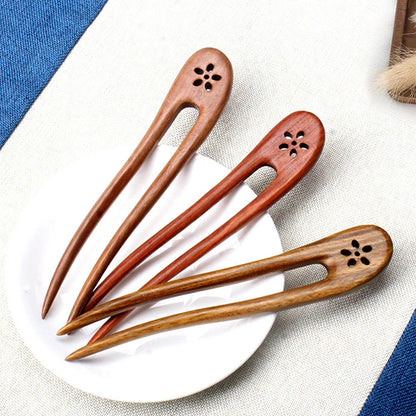 Verschiedene Holzvarianten der Élan Haarspange auf Keramikteller inszeniert