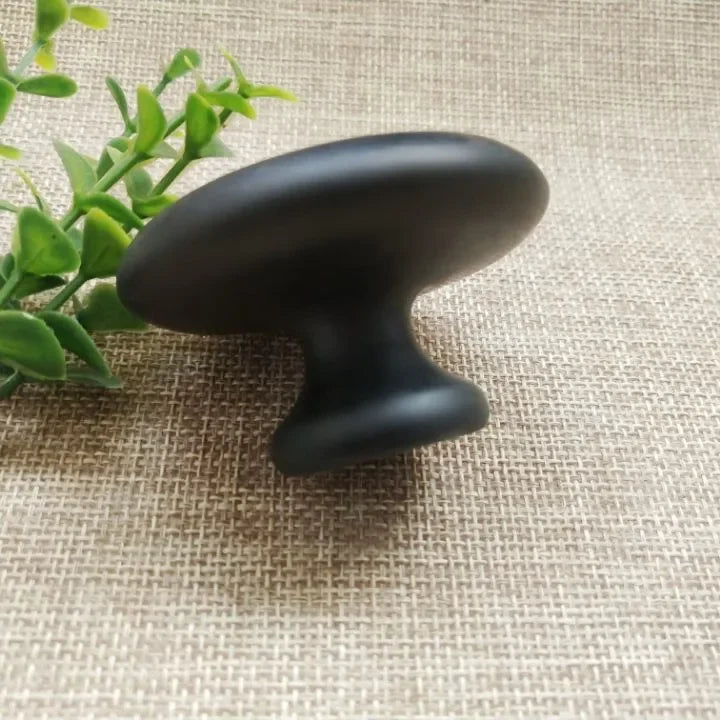 Noir Naturstein-Massagestempel auf Spa-ähnlichem Untergrund arrangiert