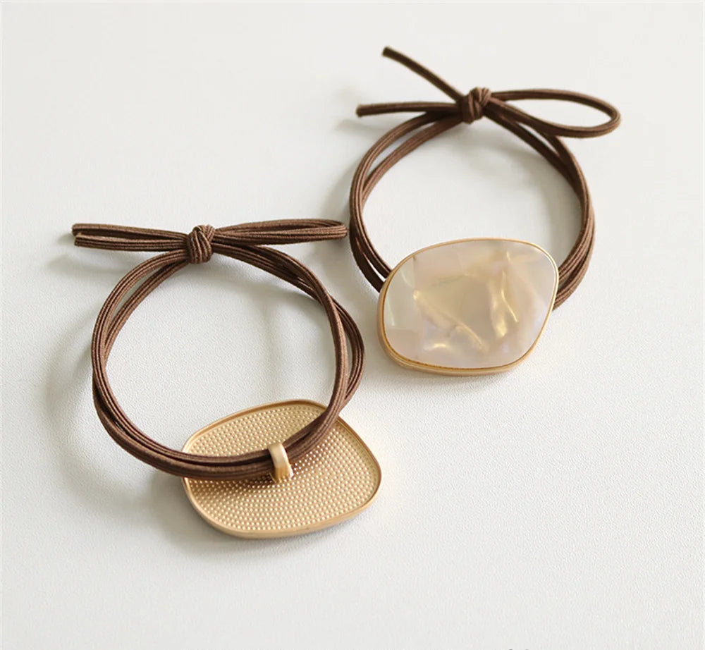 Zwei Luméa Haarbänder mit Schmuckelementen dekorativ auf Tisch arrangiert