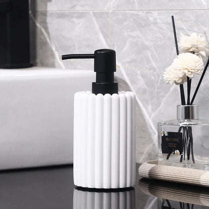 Weißer Keramik-Seifenspender mit Accessoires in hellem, zeitlosem Badezimmer